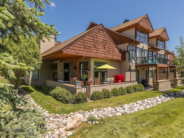 80 Crail Creek Ct Unit 616, Big Sky, MT 59716 - rear view of house featuring a yard, a chimney, a balcony, and a patio