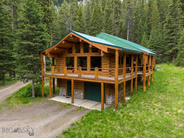 6 Arrowpoint, Silver Gate, MT 59081 - view of front of house with a forest view, log exterior, stone siding, a metal roof, and driveway