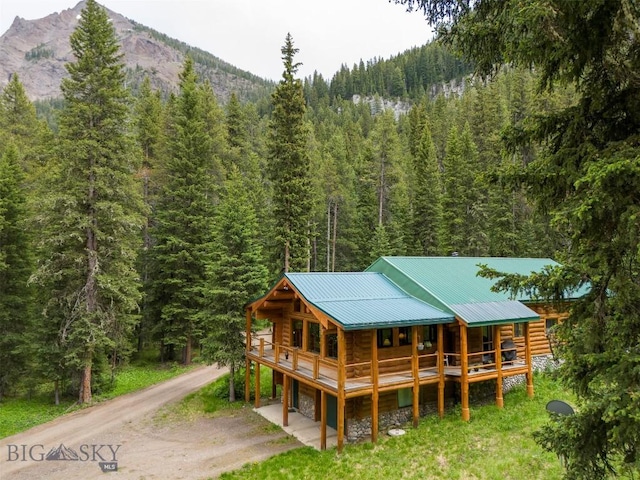 6 Arrowpoint, Silver Gate, MT 59081 - back of house featuring a wooded view, dirt driveway, log siding, a metal roof, and a mountain view