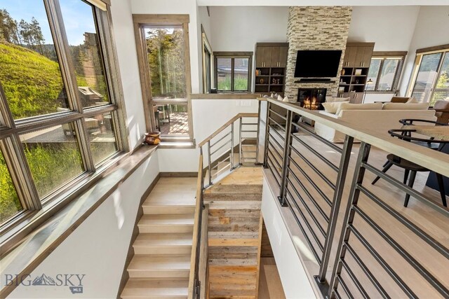 580 Outlook Trl Unit 42, Big Sky, MT 59730 - staircase with a stone fireplace and wood finished floors