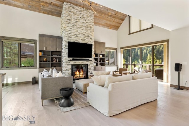 580 Outlook Trl Unit 42, Big Sky, MT 59730 - living room with high vaulted ceiling, plenty of natural light, light wood-style flooring, a fireplace, and wooden ceiling