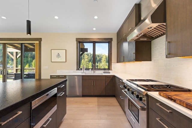 580 Outlook Trl Unit 42, Big Sky, MT 59730 - kitchen with exhaust hood, appliances with stainless steel finishes, light wood-style flooring, tasteful backsplash, and recessed lighting