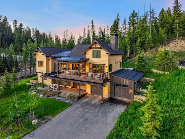 580 Outlook Trl Unit 42, Big Sky, MT 59730 - view of front of home featuring a chimney, asphalt driveway, covered porch, and an attached garage