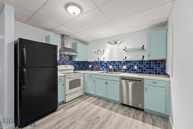 1304 Absaroka Ct, Livingston, MT 59047 - kitchen with freestanding refrigerator, wall chimney range hood, white electric stove, stainless steel dishwasher, and open shelves