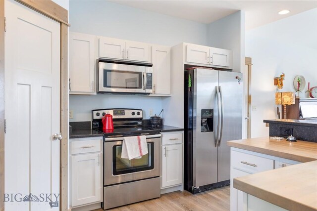 182 Snowy Owl Trl, Bozeman, MT 59718 - kitchen with stainless steel appliances, light wood-style flooring, white cabinetry, and recessed lighting