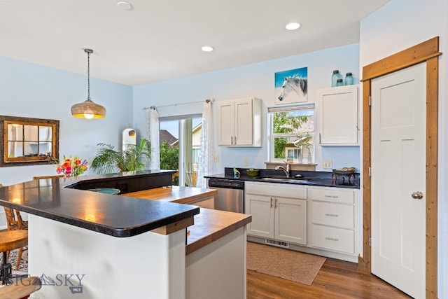 182 Snowy Owl Trl, Bozeman, MT 59718 - kitchen featuring stainless steel dishwasher, white cabinets, a breakfast bar, pendant lighting, and dark wood-style flooring