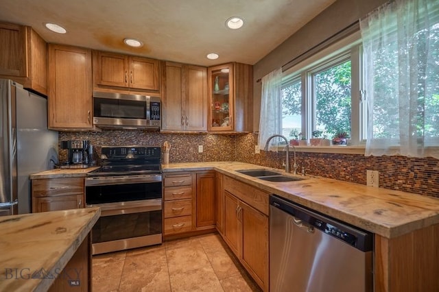 302 Ordway St S, Wilsall, MT 59086 - kitchen featuring appliances with stainless steel finishes, brown cabinets, recessed lighting, backsplash, and glass insert cabinets
