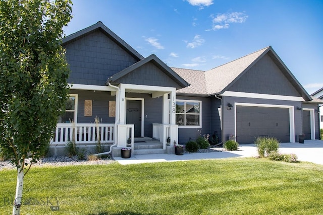 138 E Shade Tree Ln, Manhattan, MT 59741 - view of front facade featuring an attached garage, a front lawn, concrete driveway, and a porch