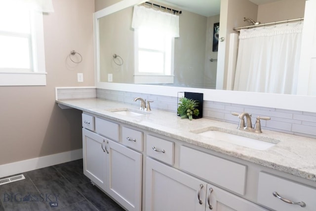 138 E Shade Tree Ln, Manhattan, MT 59741 - bathroom featuring double vanity, healthy amount of natural light, and decorative backsplash