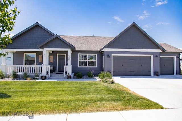 138 E Shade Tree Ln, Manhattan, MT 59741 - view of front of house featuring a garage, a front yard, driveway, and covered porch