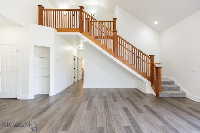894 Rogers, Bozeman, MT 59718 - unfurnished living room with high vaulted ceiling, wood finished floors, and stairs