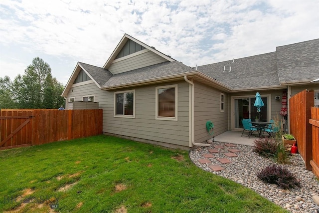 86 Tail Feather Unit C, Bozeman, MT 59718 - back of property featuring a fenced backyard, a patio, roof with shingles, and board and batten siding