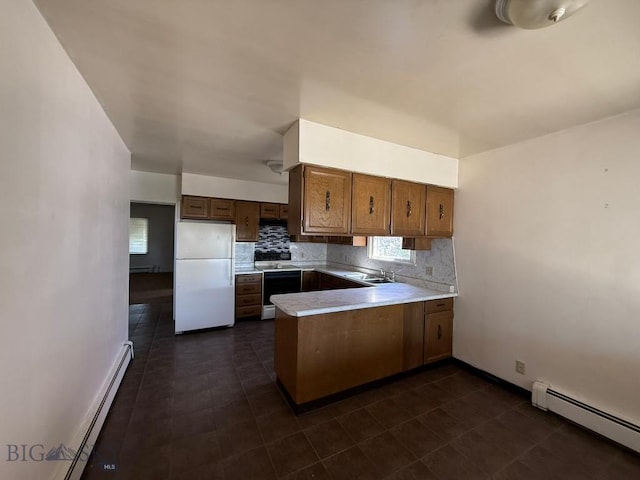 1915 S Montana, Butte, MT 59701 - kitchen with freestanding refrigerator, baseboard heating, a peninsula, and backsplash