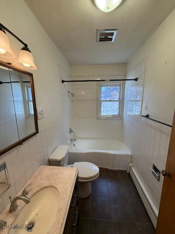 1915 S Montana, Butte, MT 59701 - full bathroom featuring tile walls, baseboard heating, tile patterned floors, bathtub / shower combination, and vanity