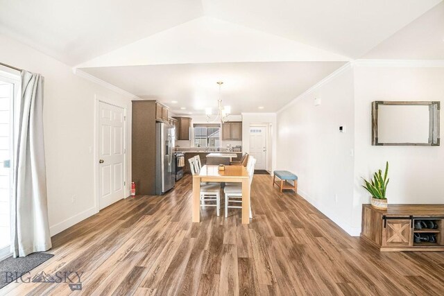 708 Pierre St, Belgrade, MT 59714 - dining space featuring wood finished floors, a chandelier, ornamental molding, recessed lighting, and vaulted ceiling