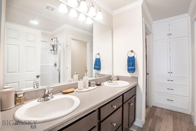 708 Pierre St, Belgrade, MT 59714 - bathroom featuring double vanity, wood finished floors, ornamental molding, and a shower with door