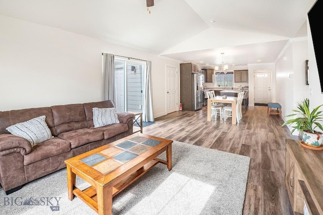 708 Pierre St, Belgrade, MT 59714 - living room featuring a chandelier, wood finished floors, and vaulted ceiling