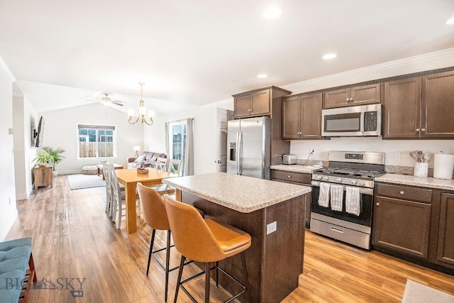 708 Pierre St, Belgrade, MT 59714 - kitchen with stainless steel appliances, open floor plan, dark brown cabinets, a center island, and recessed lighting