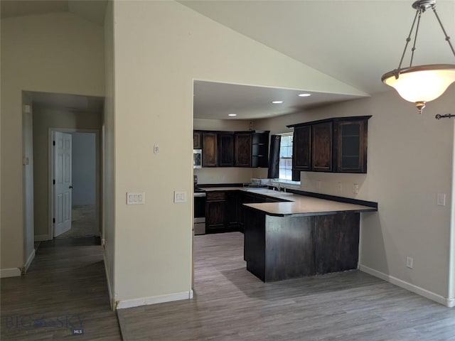 477 W River Rock, Belgrade, MT 59714 - kitchen with dark brown cabinets, a peninsula, wood finished floors, appliances with stainless steel finishes, and high vaulted ceiling