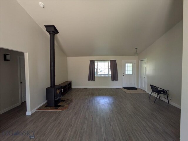 477 W River Rock, Belgrade, MT 59714 - unfurnished living room featuring a wood stove, wood finished floors, and high vaulted ceiling
