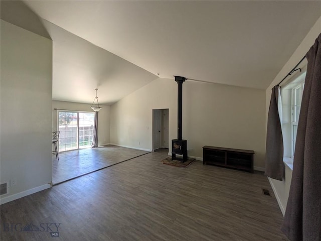 477 W River Rock, Belgrade, MT 59714 - unfurnished living room with vaulted ceiling, wood finished floors, and a wood stove