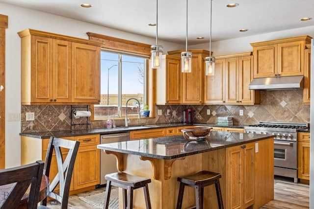 3609 Fieldstone W, Bozeman, MT 59715 - kitchen with stainless steel appliances, under cabinet range hood, a center island, light wood finished floors, and recessed lighting
