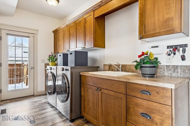 3609 Fieldstone W, Bozeman, MT 59715 - laundry room featuring washing machine and clothes dryer, cabinet space, and light wood-style floors