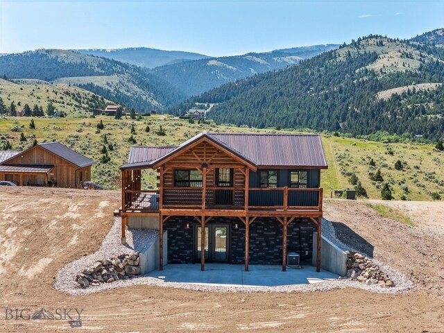 209 W Madison St, Virginia City, MT 59755 - view of front facade with a patio area, a metal roof, and a deck with mountain view