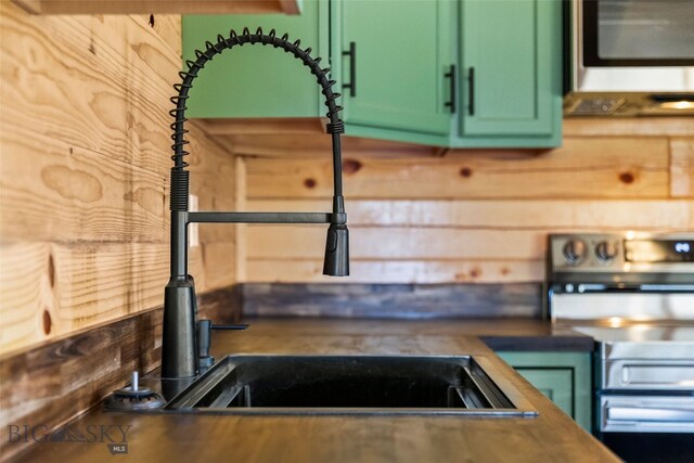 209 W Madison St, Virginia City, MT 59755 - kitchen featuring appliances with stainless steel finishes, green cabinetry, and wood walls