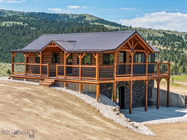209 W Madison St, Virginia City, MT 59755 - view of front of house featuring a wooded view, a mountain view, and a metal roof