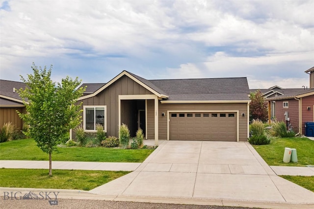 152 Goldcrest Ln, Bozeman, MT 59715 - view of front facade featuring board and batten siding, a garage, a front yard, concrete driveway, and solar panels