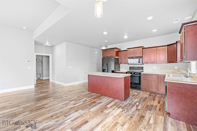 152 Goldcrest Ln, Bozeman, MT 59715 - kitchen featuring black appliances, a center island, light wood-type flooring, light countertops, and recessed lighting