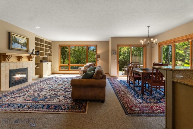3300 E Graf Unit 26, Bozeman, MT 59715 - living room with a chandelier, carpet floors, a textured ceiling, built in features, and a fireplace