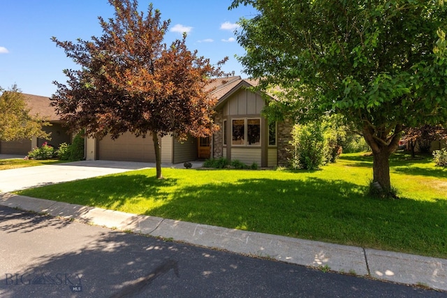 3300 E Graf Unit 26, Bozeman, MT 59715 - obstructed view of property featuring concrete driveway, a front lawn, a garage, and board and batten siding
