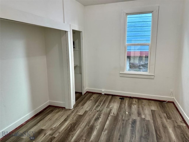 110 E Center St, Butte, MT 59701 - unfurnished bedroom with wood finished floors, a closet, and multiple windows