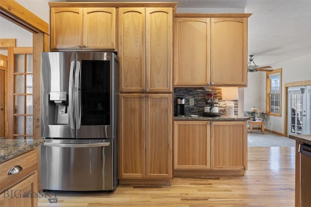 34 W Katina Ct, Bozeman, MT 59718 - kitchen with stainless steel appliances, dark stone countertops, tasteful backsplash, light wood-style flooring, and a ceiling fan