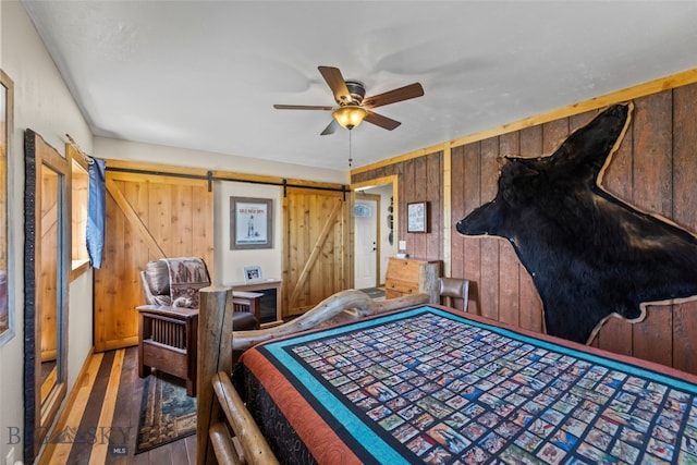 30 Hayfield Loop Trl, Ennis, MT 59729 - bedroom featuring wooden walls, wood finished floors, and a barn door