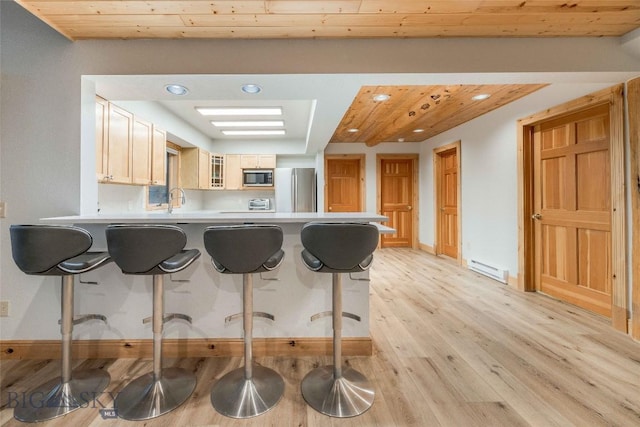 8 Ringneck Dr, Big Sky, MT 59716 - kitchen with built in microwave, freestanding refrigerator, a peninsula, light wood-style flooring, and glass insert cabinets