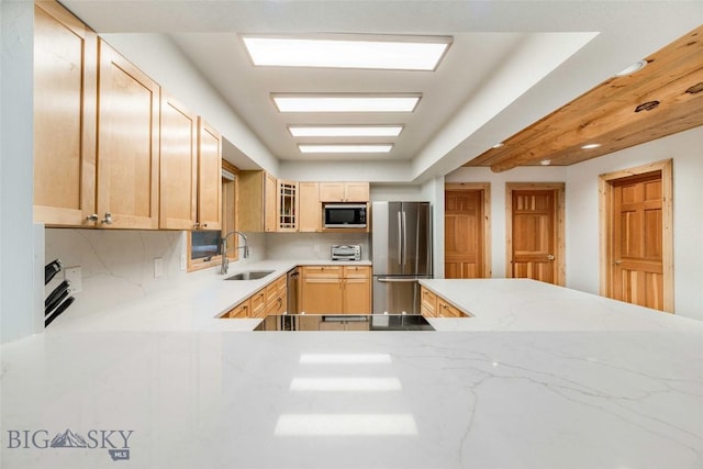 8 Ringneck Dr, Big Sky, MT 59716 - kitchen with appliances with stainless steel finishes, tasteful backsplash, light brown cabinets, glass insert cabinets, and light stone countertops