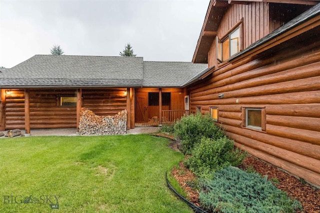 8 Ringneck Dr, Big Sky, MT 59716 - back of property featuring log siding, board and batten siding, a shingled roof, and a yard
