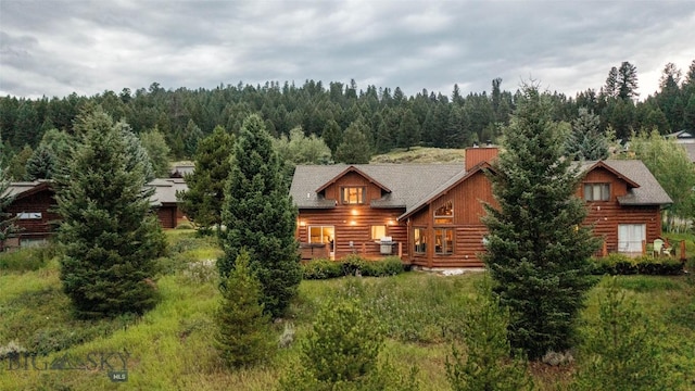8 Ringneck Dr, Big Sky, MT 59716 - back of house with a view of trees, a chimney, and log exterior