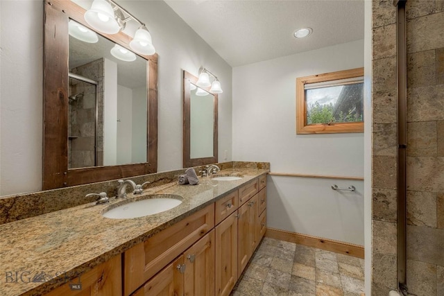 8 Ringneck Dr, Big Sky, MT 59716 - bathroom featuring double vanity, tiled shower, and stone finish floors