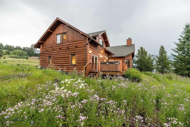 8 Ringneck Dr, Big Sky, MT 59716 - view of home's exterior featuring a deck, a chimney, and log siding