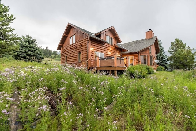8 Ringneck Dr, Big Sky, MT 59716 - back of property with a chimney, a wooden deck, and log siding