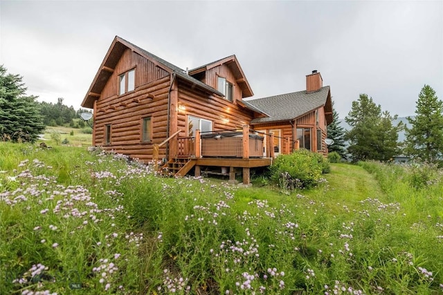 8 Ringneck Dr, Big Sky, MT 59716 - rear view of property featuring a chimney, a wooden deck, and log siding