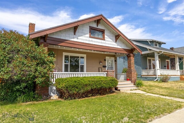 1039 Placer St, Butte, MT 59701 - view of front of home featuring a porch, a chimney, and a front yard