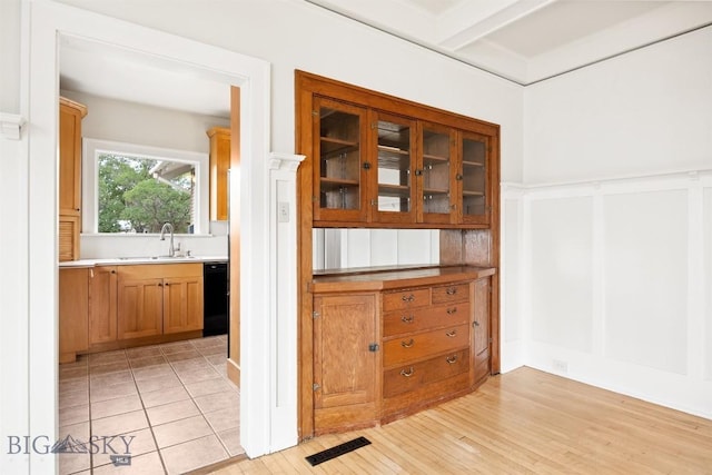 1039 Placer St, Butte, MT 59701 - bar area featuring dishwasher, light wood-type flooring, a decorative wall, and wainscoting