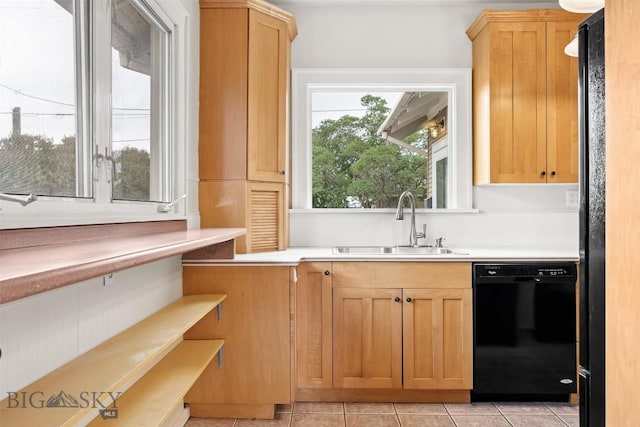 1039 Placer St, Butte, MT 59701 - kitchen with black dishwasher, light countertops, light tile patterned floors, and light brown cabinets