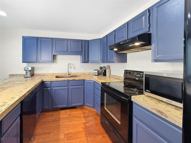 80 Aspen Leaf Dr Unit 7, Big Sky, MT 59716 - kitchen featuring black appliances, under cabinet range hood, blue cabinetry, light countertops, and light wood finished floors