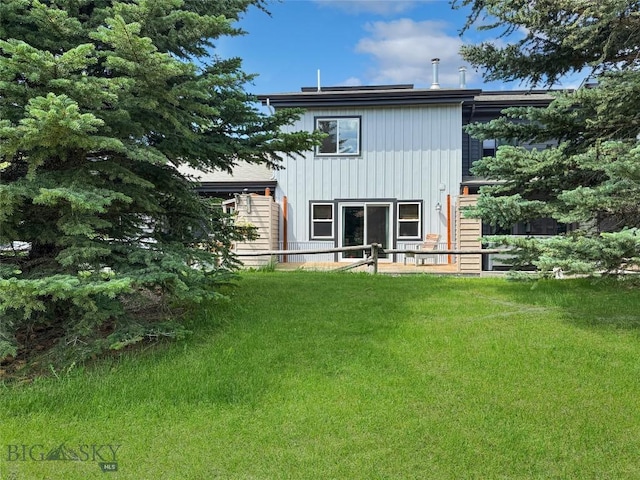 80 Aspen Leaf Dr Unit 7, Big Sky, MT 59716 - back of house with board and batten siding and a lawn